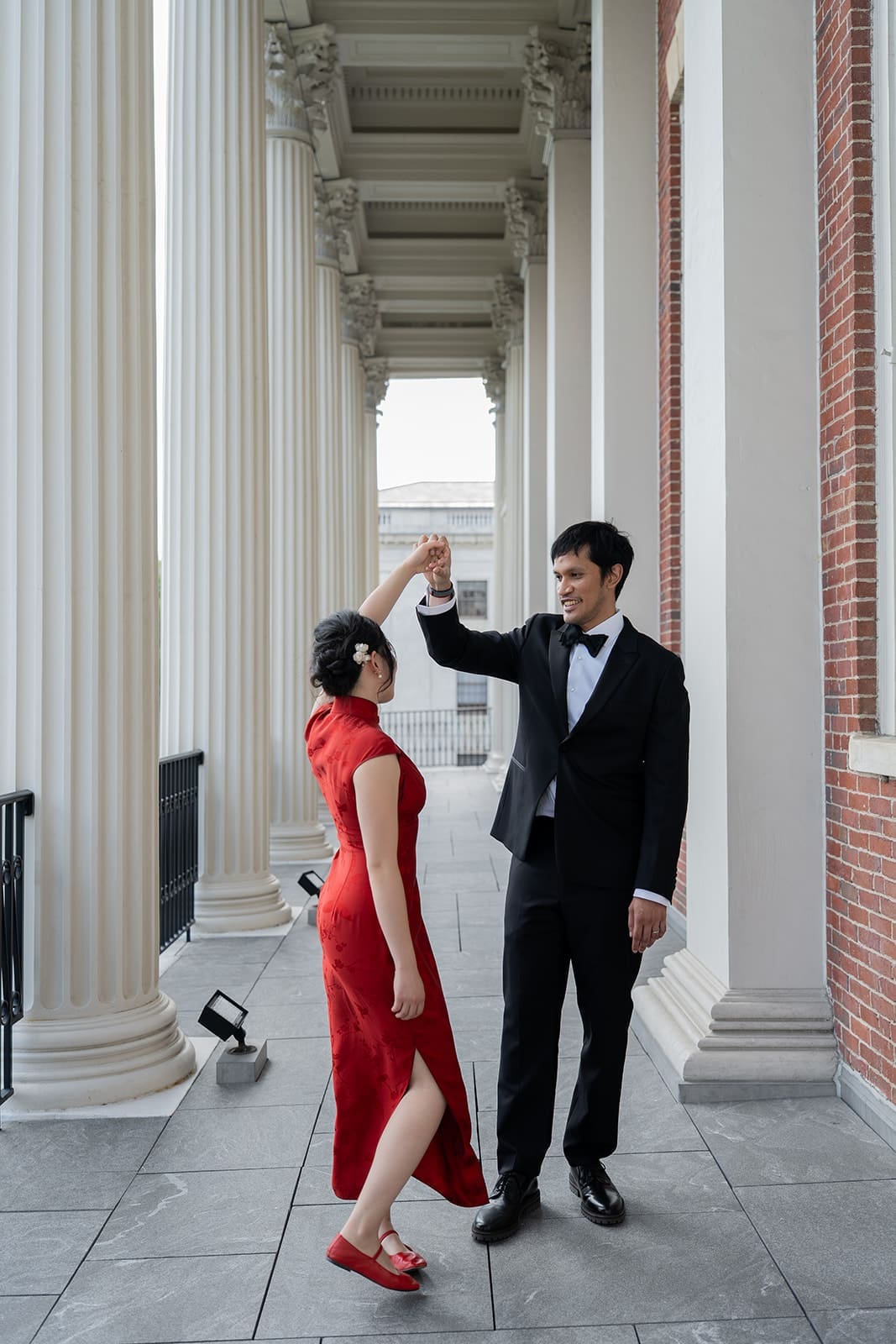 Newlyweds twirl beneath the white columns of a historic Boston building.