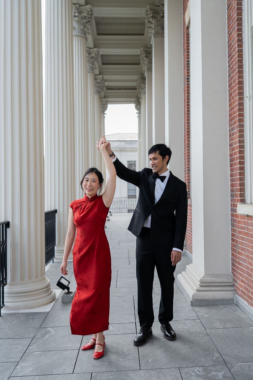 Newlyweds dance beneath the white columns outside a historic Boston building.