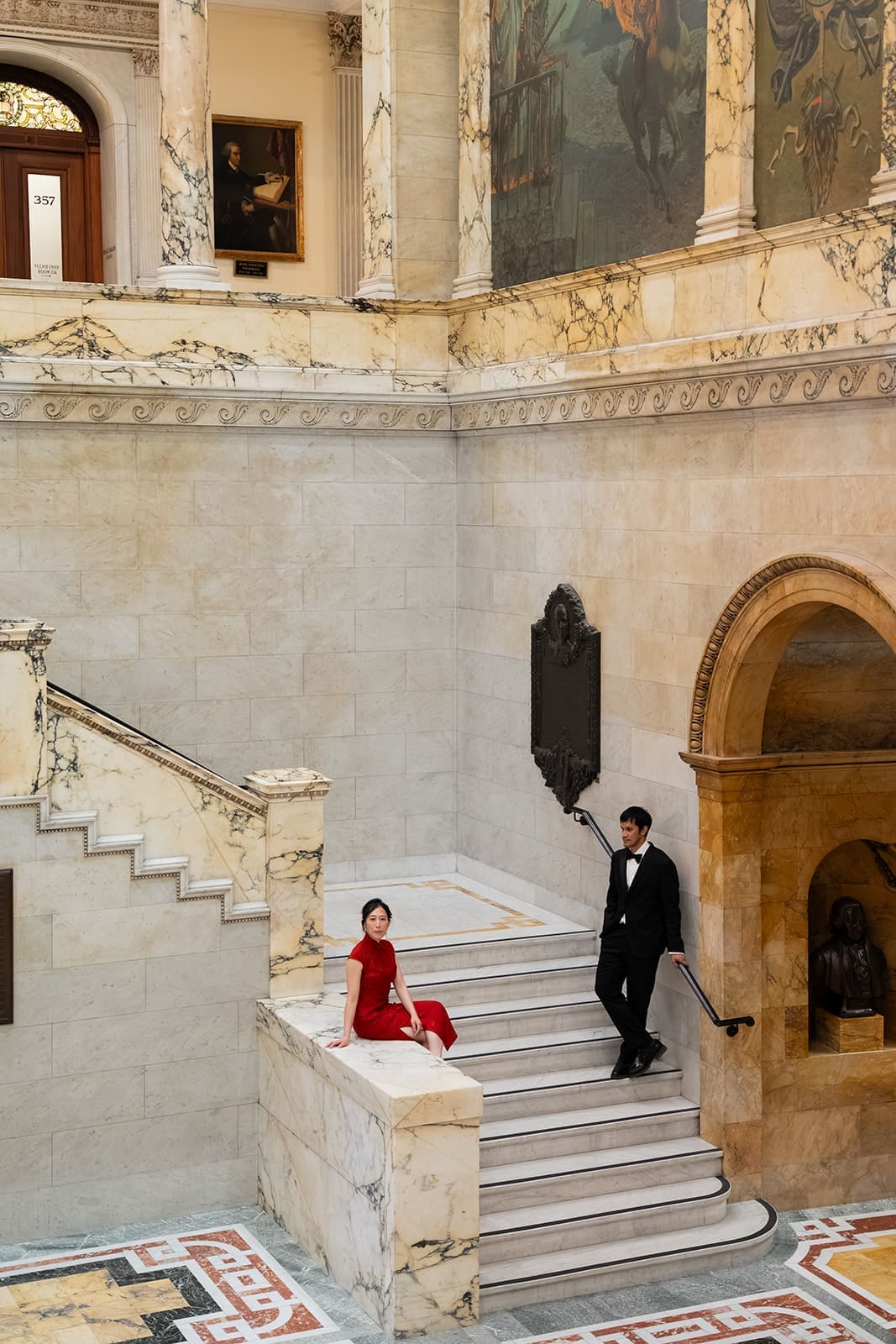 Couple poses on the marble staircase inside Boston City Hall after their ceremony.