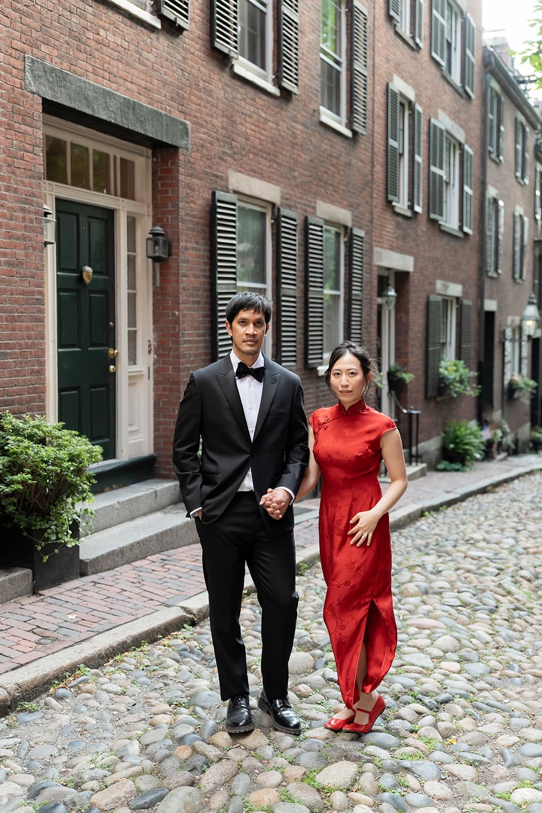 Couple walks hand in hand along a cobblestone street in Boston’s Beacon Hill neighborhood.