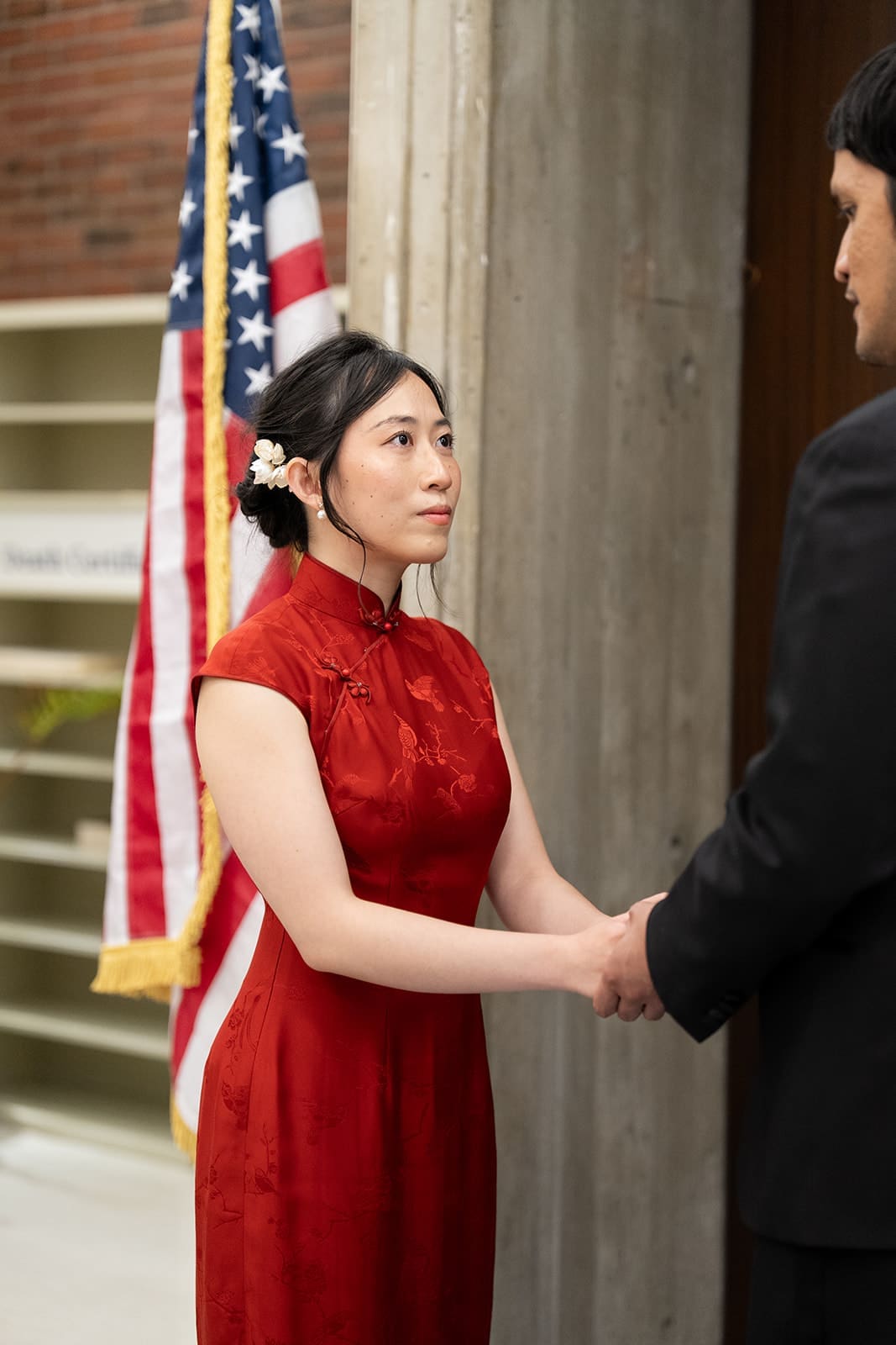 Bride holds her partner’s hands during an intimate Boston City Hall wedding ceremony.