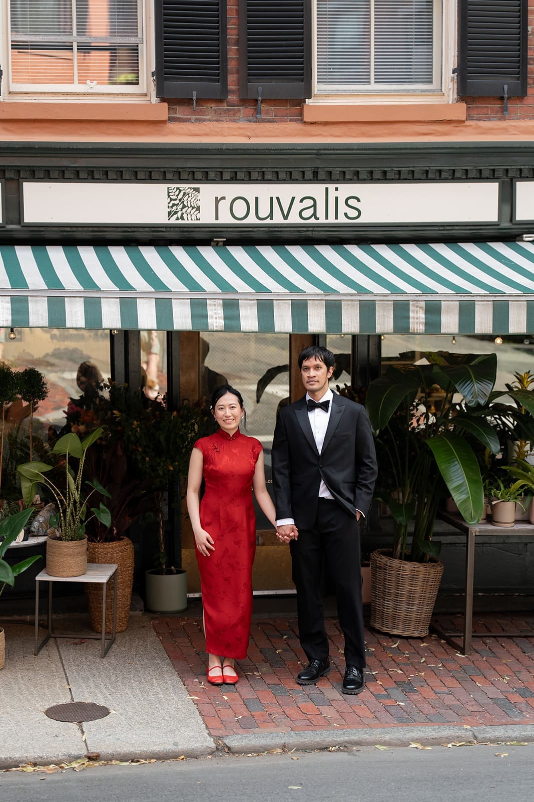 Newlyweds hold hands outside Rouvalis Flowers in Boston’s Beacon Hill neighborhood.