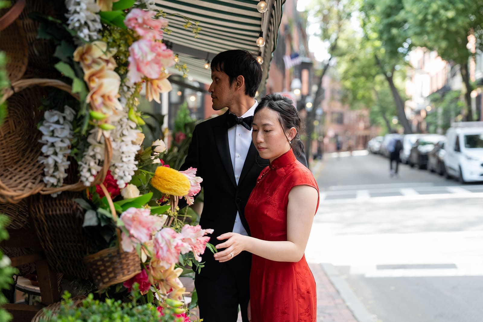 Couple browses colorful flowers at an outdoor flower shop after their Boston City Hall wedding.