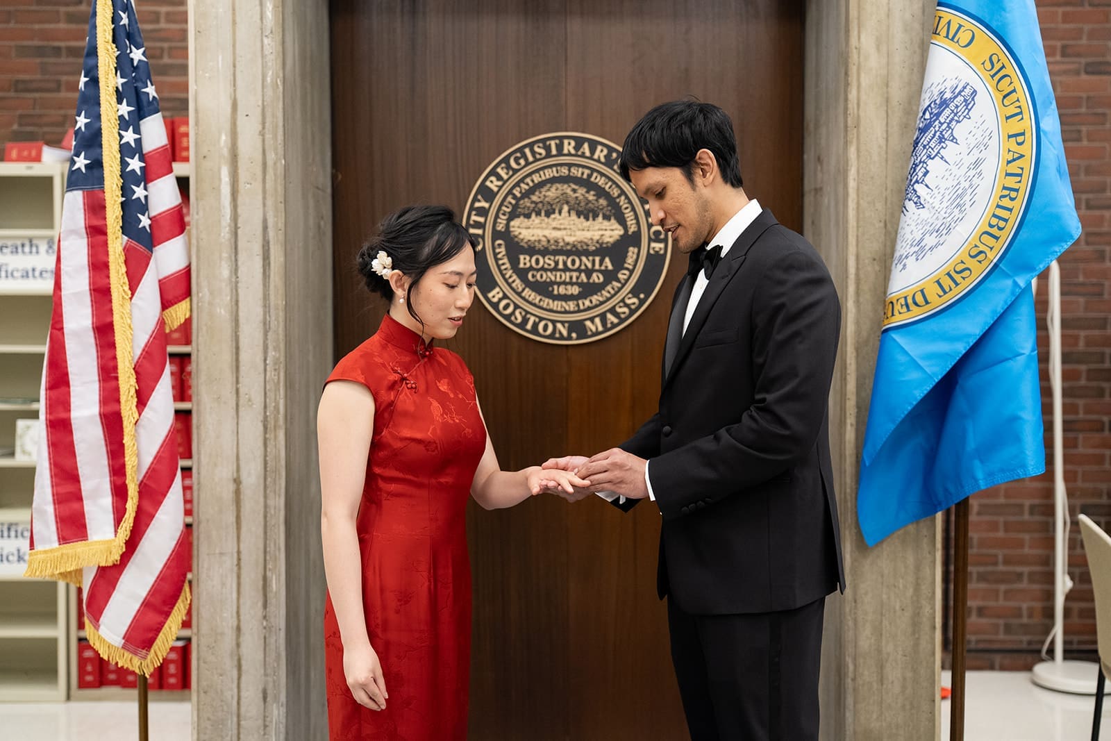 Groom places a wedding ring on his partner’s hand during their City Hall ceremony.