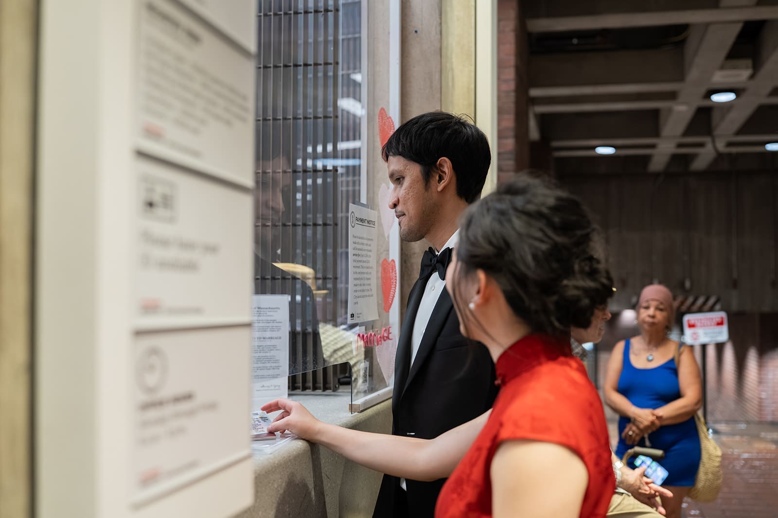 Couple submits their marriage paperwork at a service window inside Boston City Hall.