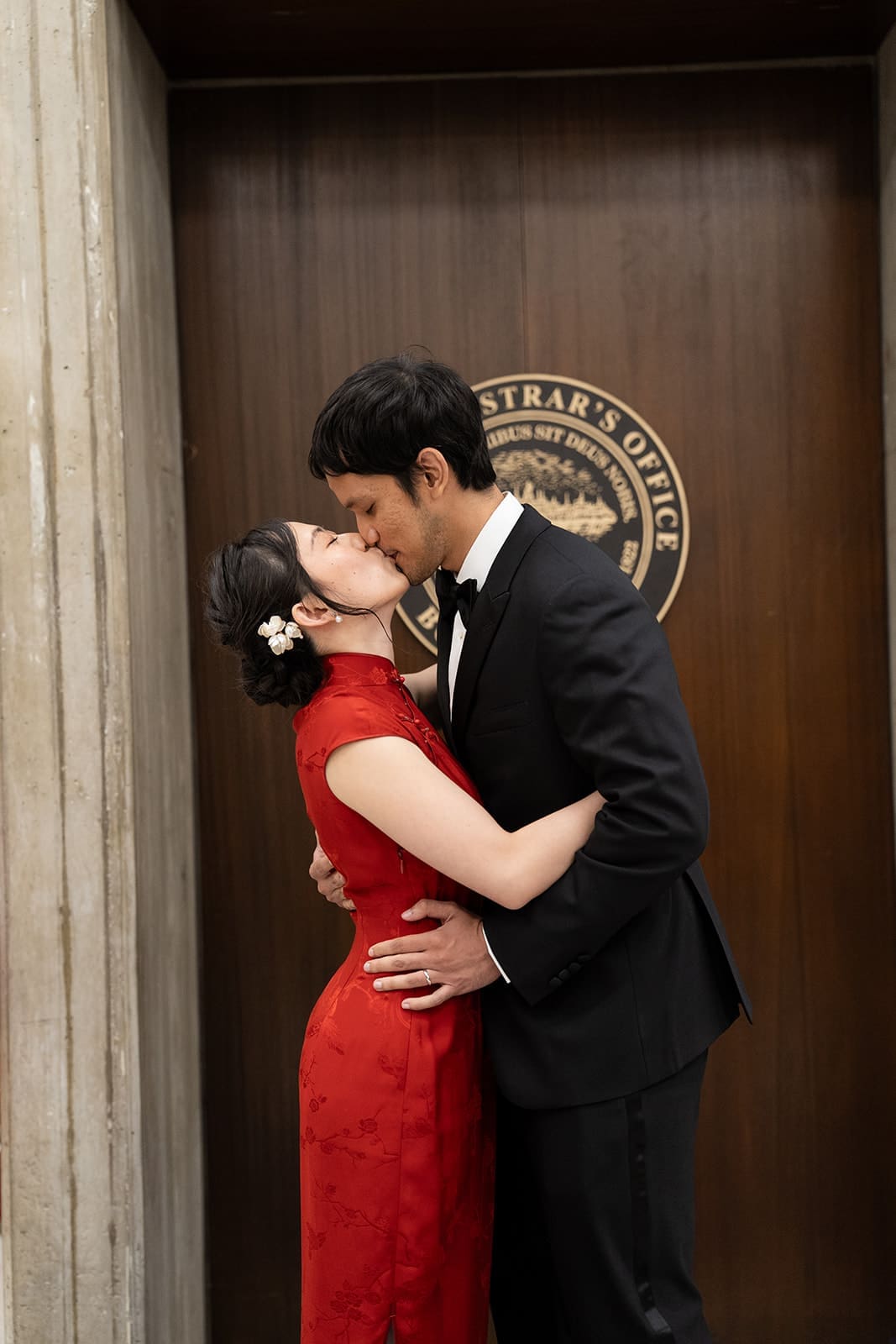 Newlyweds kiss in front of the Boston Registry Division doors.