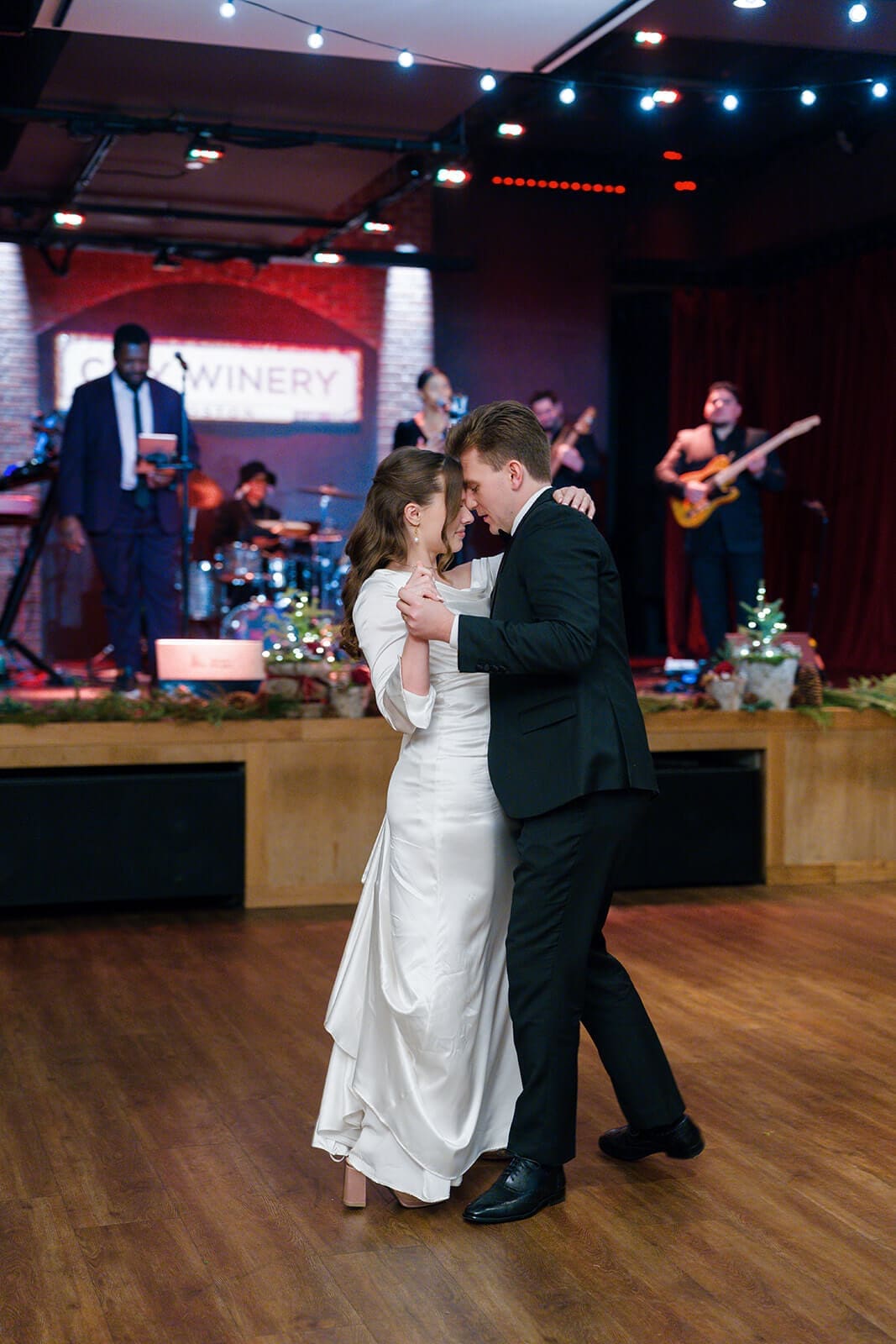 Candid wedding photos of the newlyweds sharing their first dance in front of the live band.