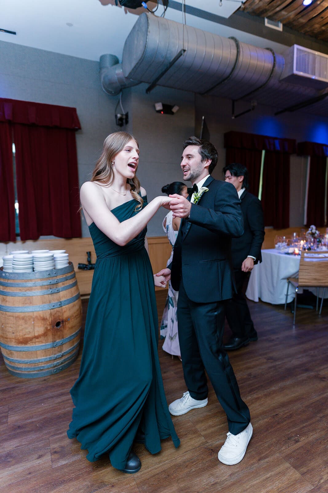 Candid wedding photos of a couple laughing and dancing together during the reception.