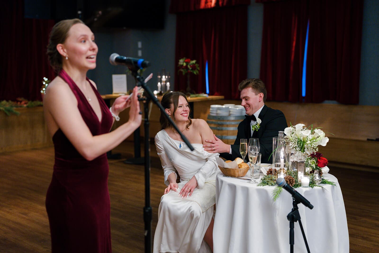 Candid wedding photos of a bridesmaid giving a speech while the newlyweds laugh at their table.