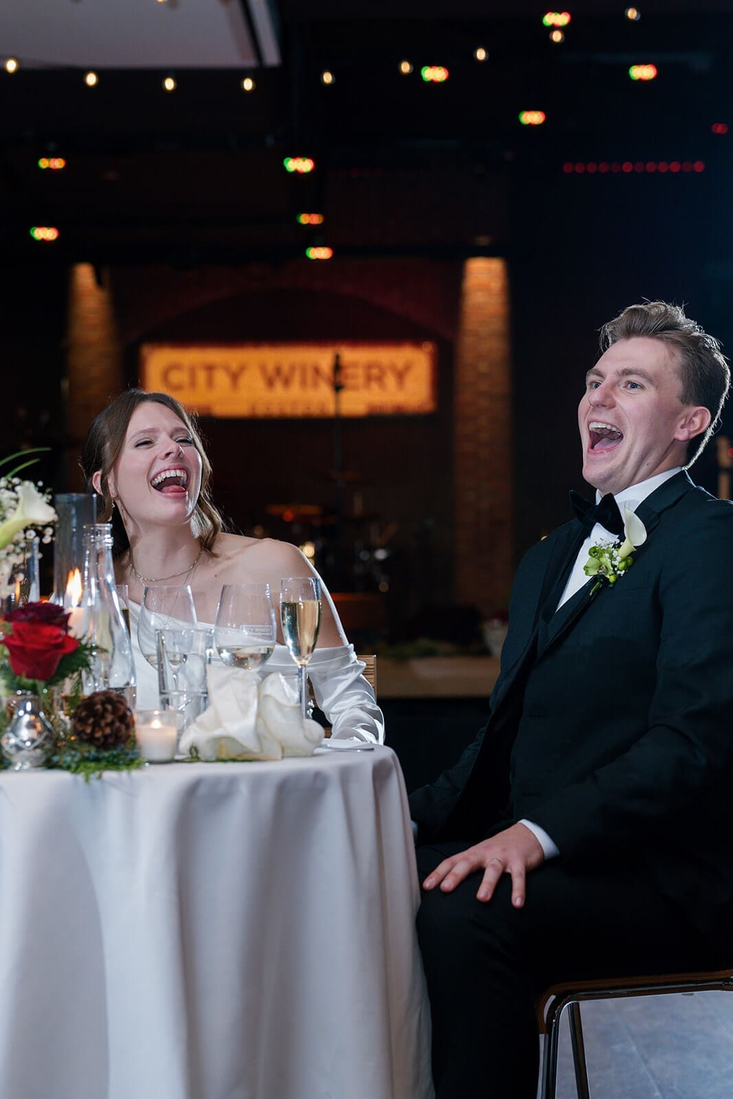 Candid wedding photos of the bride and groom laughing together during a reception speech.