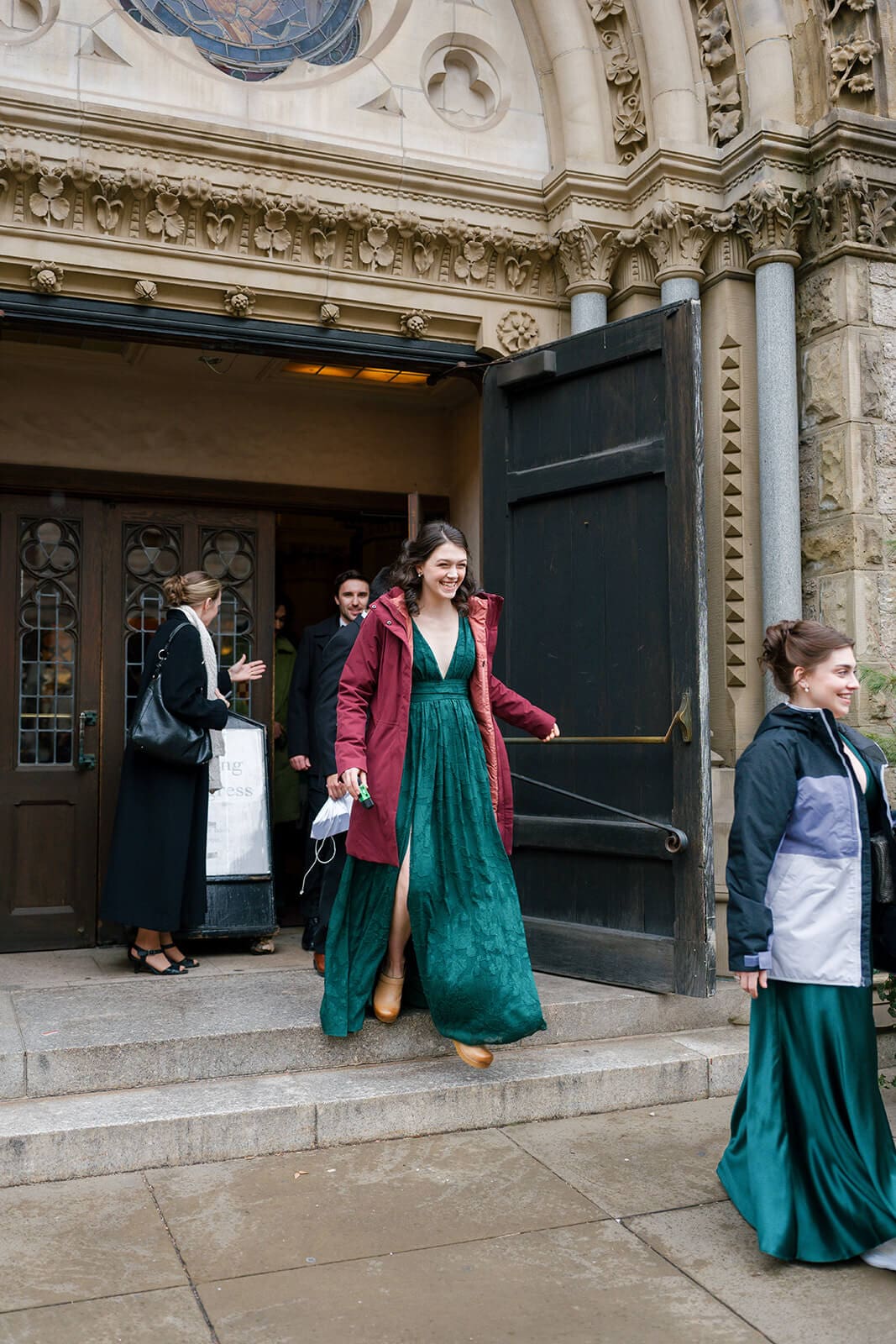 Wedding guests leaving a historic Boston church after the ceremony in colorful formal attire.