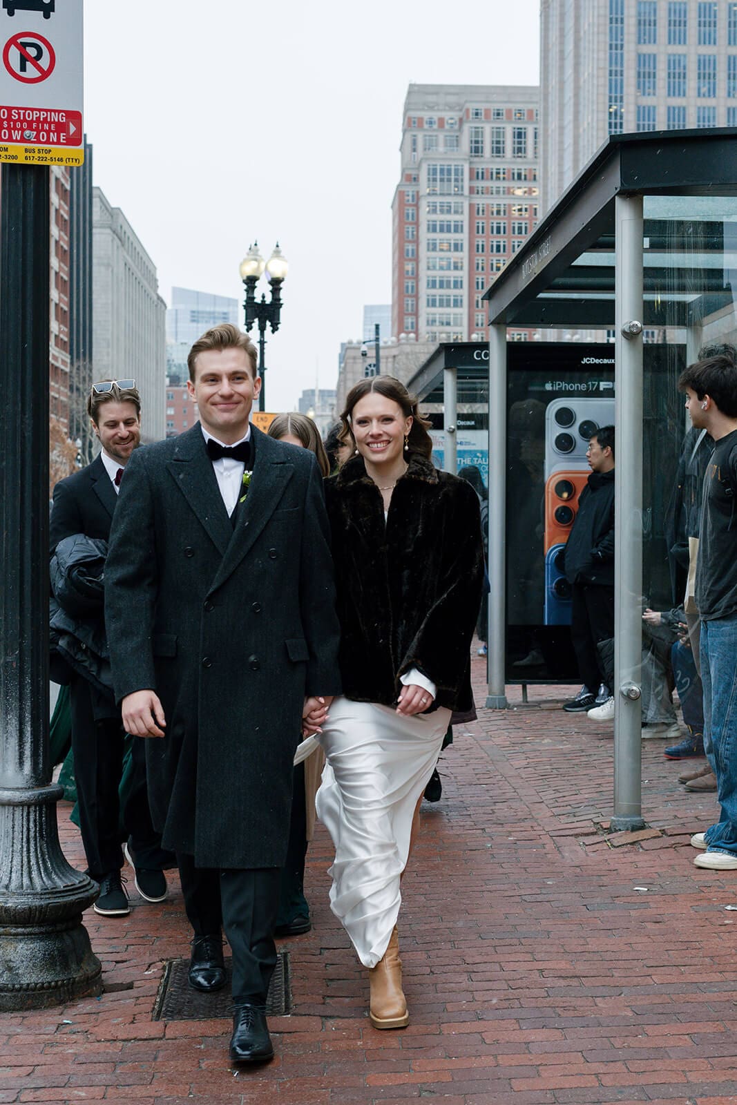 Bride and groom walking through Copley Square in Boston with members of their wedding party.