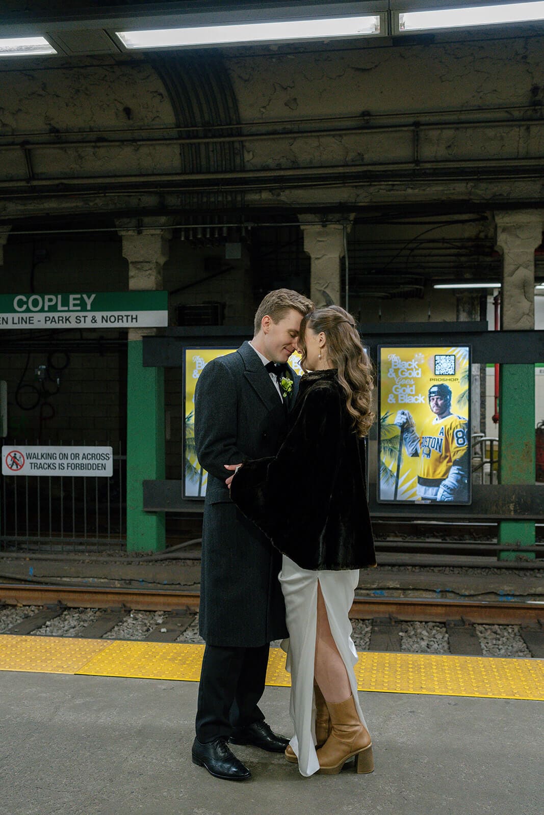 Newlyweds embracing on the Green Line platform at Copley station after their Boston wedding ceremony.