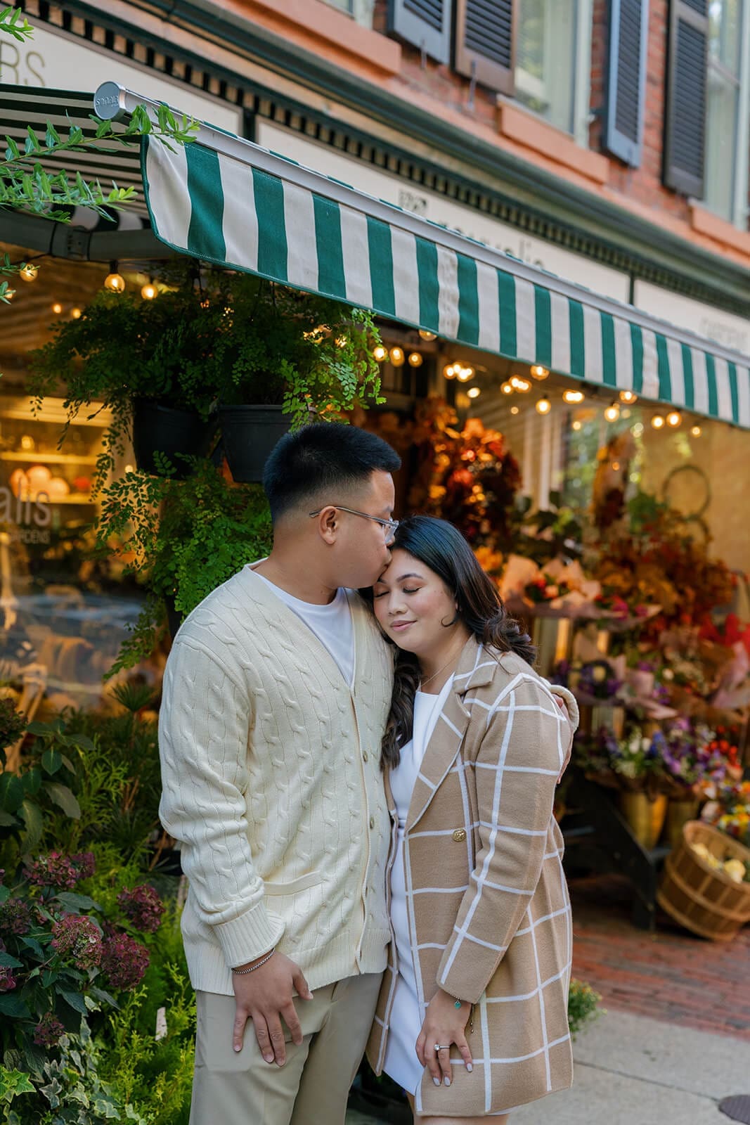 Couple leaning into each other for a quiet portrait outside a colorful Beacon Hill flower shop.