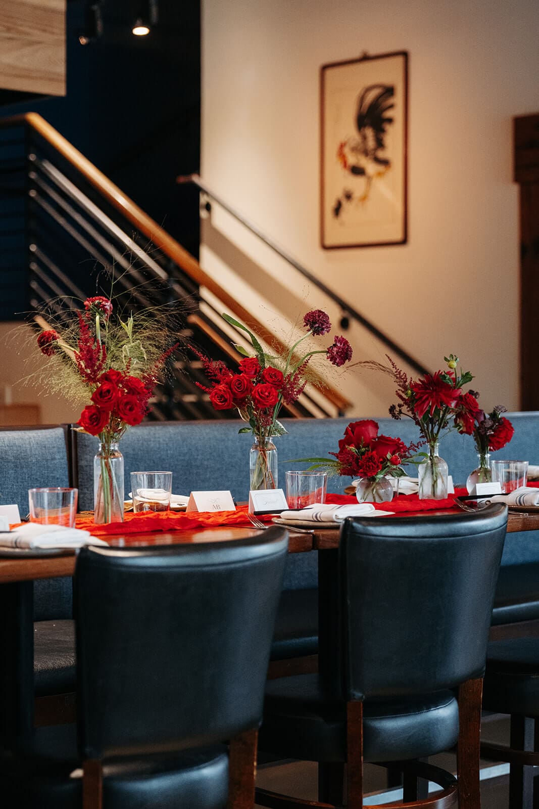 Reception dining area decorated with red flowers and red table runners for a pagu restaurant wedding.