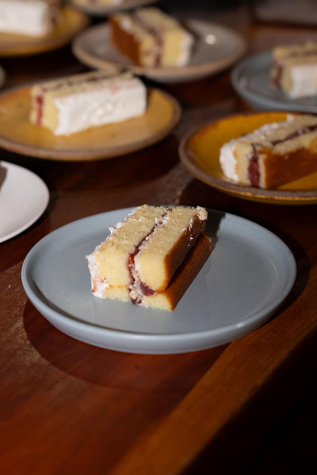 Slices of layered wedding cake with fruit filling served on individual plates during a pagu restaurant wedding.