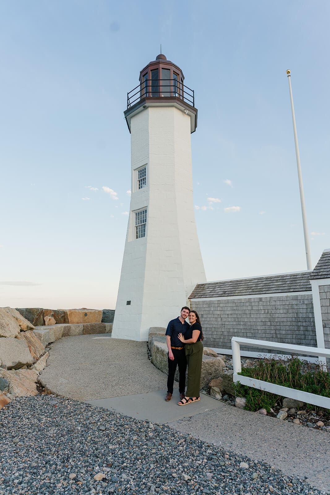 Couple standing together at the base of Scituate Lighthouse